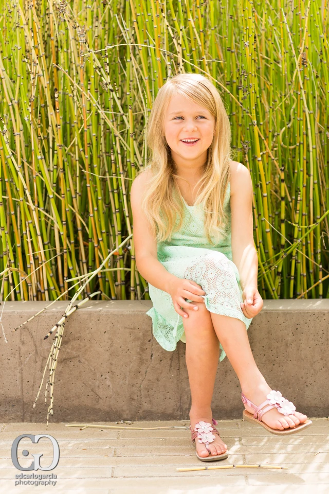 Young model seated in a mint dress outdoors