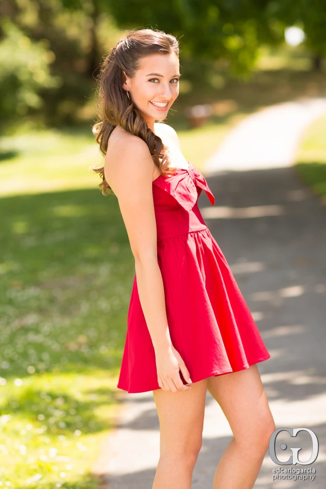 Teen model in a red dress on a sunlit path